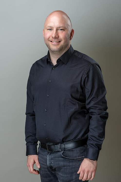 Alexander Ewers vor hellgrauem Hintergrund